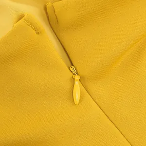 Close-up view of the invisible back zipper on a vibrant yellow French slip evening gown.