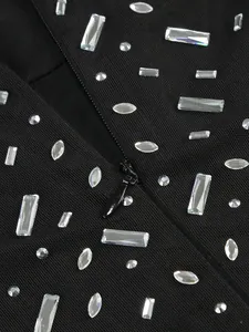 Close-up of sparkling silver rhinestones on black mesh fabric with a hidden zipper.