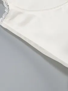 Macro view showing the intricate lace trim and white mesh lining of a premium cocktail dress