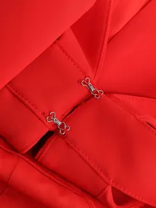 Close-up of the secure hook-and-eye fastener on the red high-waisted wide-leg trousers.