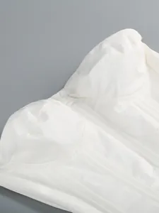 Primo piano del corpino di un abito a fascia bianco strutturato con cuciture a vista