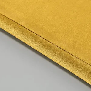 Macro detail shot showing the golden satin fabric and precise stitching of the gown