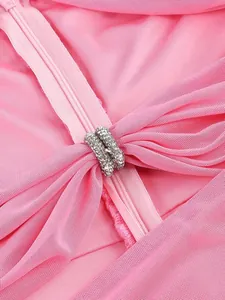 Close-up detail of pink ruched cocktail dress with sparkling rhinestone ring accents