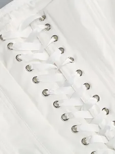 Dettaglio dell'allacciatura posteriore di un elegante corsetto bianco con nastri in raso