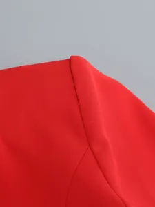 Detailed close-up view of a vibrant red suit jacket showing shoulder seam and fabric