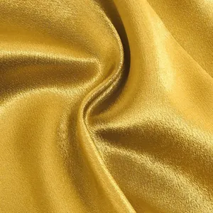 Detailed macro view of luxurious high-end golden satin fabric texture for elegant evening dress