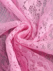 Close-up macro view of delicate pink floral lace fabric texture for elegant dresses