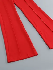 Close-up detail of red flare leg trousers showing center crease and hem stitching