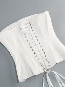 Dettaglio di un elegante corsetto bianco stringato con nastri in raso lucido per abito