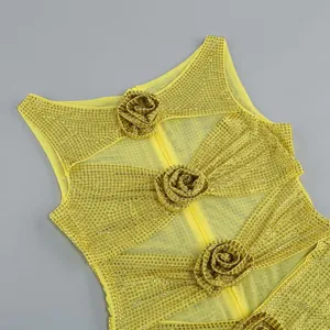 Detailansicht eines gelben Mesh-Kleides mit goldenen Strasssteinen und Stoffrosen