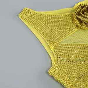 Detaillierte Nahaufnahme eines gelben Strass-Abendkleides mit 3D-Blumenapplikationen