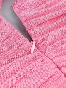 Detailed macro view of pink ruched mesh fabric and matching invisible zipper for dress