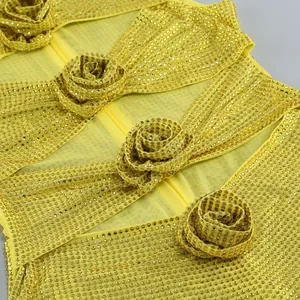 Detailansicht des gelben Kleides mit Strasssteinen und eleganten Blumenverzierung.