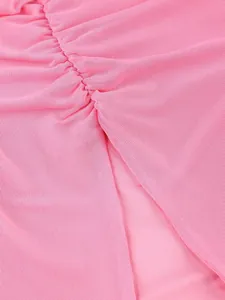 Detailed view showing the ruched texture and high slit design of a pink dress