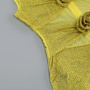 Detailaufnahme eines gelben Netzkleides mit glänzenden Strasssteinen und Blumenverzierung