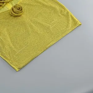 Detailansicht von gelbem, glitzerndem Strassgewebe mit einer dekorativen 3D-Blume