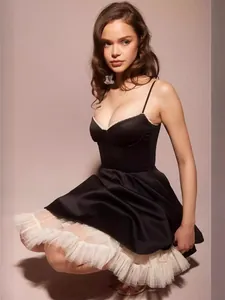 Elegant black spaghetti strap mini dress featuring a white puffy mesh petticoat detail