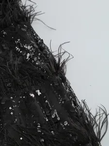 Macro detail of black sequins and ostrich feathers on a luxurious evening dress