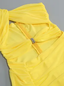 Detail of a yellow ruched mesh formal dress with rhinestone buckle and zipper closure.