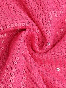 Detalle macro de tela de lentejuelas rosa vibrante con textura rica y brillo elegante