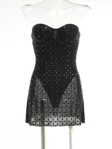 Close-up of black strapless mini dress with heavy rhinestone embellishments and sheer hem