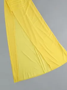 Detailed view of a bright yellow dress featuring a high side slit and elegant side ruching
