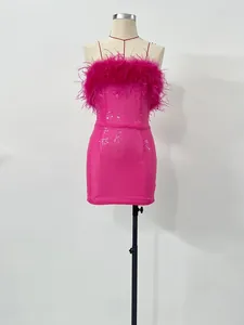 Detalle de un minivestido rosa de lentejuelas con ribete de plumas de avestruz