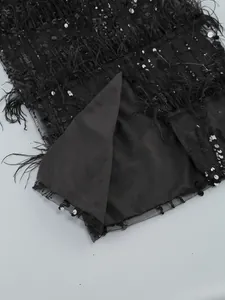 Close-up detail of black sequined dress with ostrich feathers and smooth inner lining.