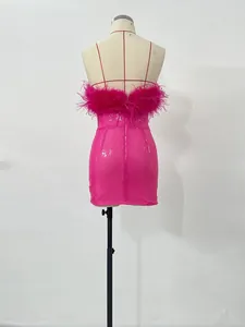 Vista trasera de un minivestido fucsia de lentejuelas con plumas de avestruz.