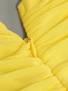 Macro view showing the hidden zipper and pleated mesh texture of this yellow formal dress
