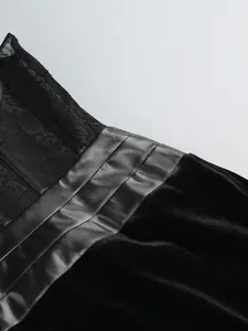 Detailansicht mit schwarzer Spitze, plissiertem Satinbesatz und weicher Samttextur des Kleides.