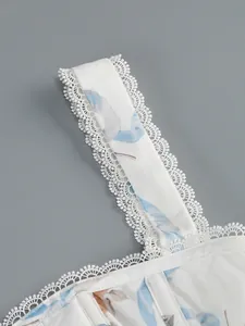 Gros plan d'une bretelle de robe à fleurs avec dentelle blanche et détails de couture.