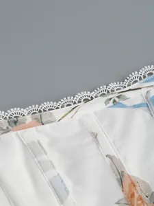 Vue rapprochée de la délicate bordure en dentelle blanche et du motif floral de robe