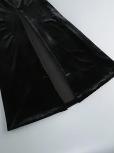 Makro-Detail eines luxuriösen schwarzen Samtkleides mit einem stilvollen hohen Schlitz.