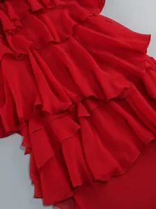 Detailed macro view of vibrant tiered red ruffles on an elegant sheer chiffon maxi dress