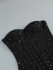 Close-up detail of a black strapless dress with heavy rhinestone grid embellishments.