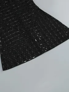 Detailed view of the intricate black rhinestone grid pattern on a heavy-duty mini dress