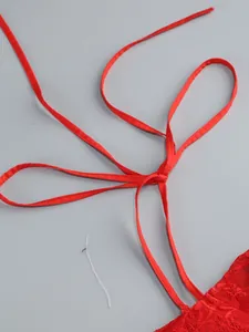 Detail shot of red lace top straps with adjustable tie design and fine stitching