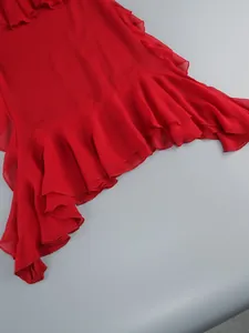 Close-up of the vibrant red ruffled hemline on a sexy halter neck maxi dress