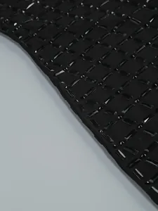 Detailed close-up of heavy luxury rhinestone embellishments on black mesh dress fabric