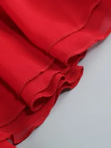 Close-up of red ruffled hem and fabric texture of an elegant halter dress.