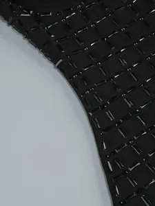 Macro view of high-quality black rectangular rhinestones and beads on mesh dress fabric.