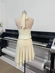 Detailed back view of a chic cream halter top and ruffled mesh mini skirt set on a mannequin