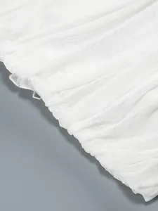 Vista detallada de la textura del tejido de malla blanca fruncida para un vestido elegante