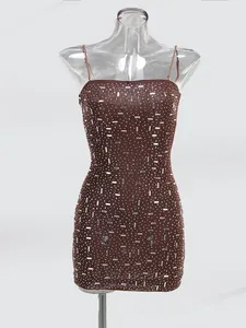 Dettaglio mini abito marrone attillato con decorazioni in strass argento lucido.