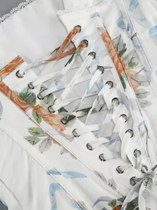 Vue détaillée d'une robe blanche à fleurs avec laçage et œillets métalliques fins.