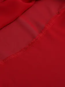 Macro detail of red sheer chiffon fabric showing high-quality stitching and hem