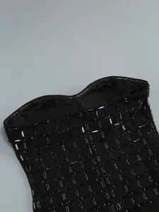 Close-up macro view showing the heavy black rhinestone grid pattern on a strapless dress