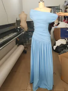 Detail view of an elegant light blue one-shoulder pleated maxi dress on a dress mannequin