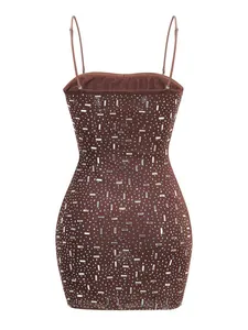 Dettaglio di un abito attillato marrone caffè con strass argentati geometrici.